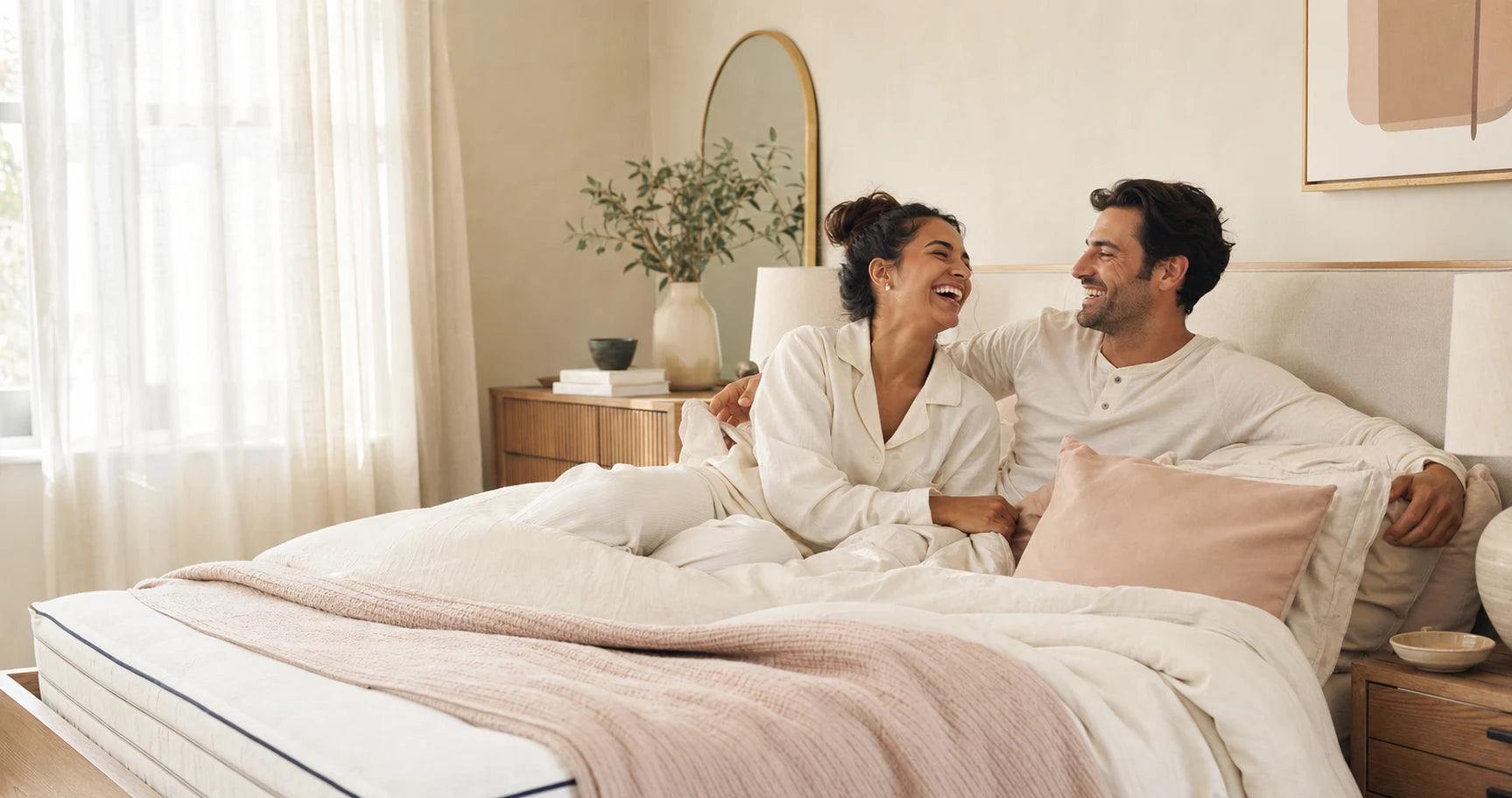 A happy couple relaxing together in a bright bedroom